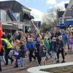 Schooljeugd loopt Palmpaasoptocht in Akkrum